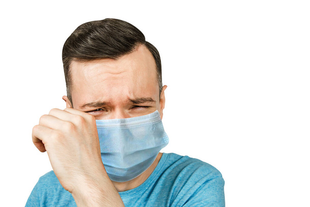 Unhappy, cry young man wearing a protective face mask prevent virus infection or pollution on white isolated background. - Foto, Bild