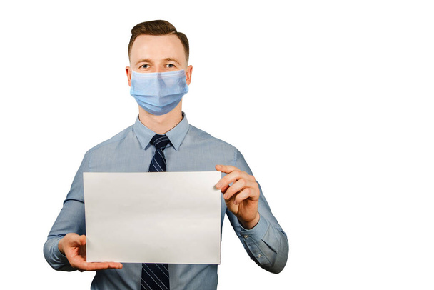 man holding blank sheet of paper a4, wearing a protective face mask prevent virus infection on white isolated background. - Foto, Imagem
