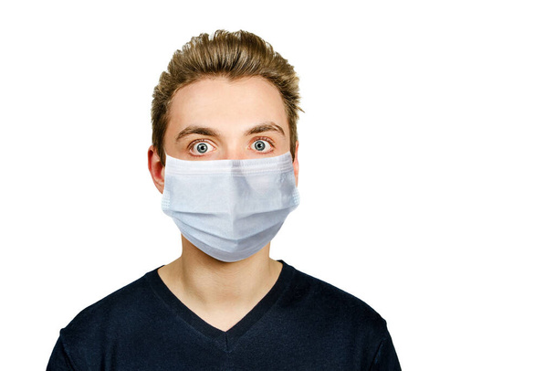 Unhappy, sad young man wearing a protective face mask prevent virus infection or pollution on white isolated background. - Фото, изображение
