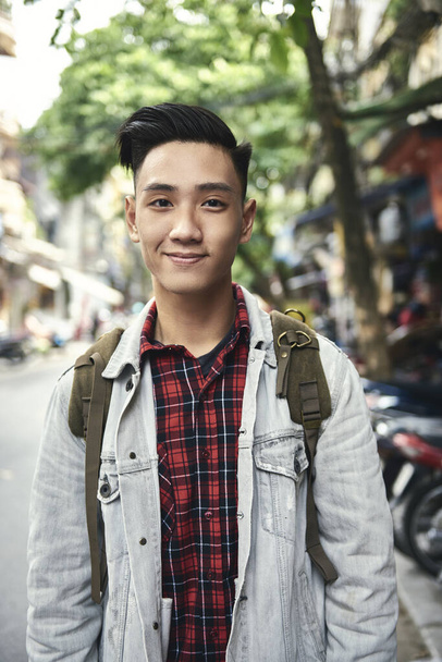 Portrait of young Vietnamese man with backpack in the city  - Photo, Image