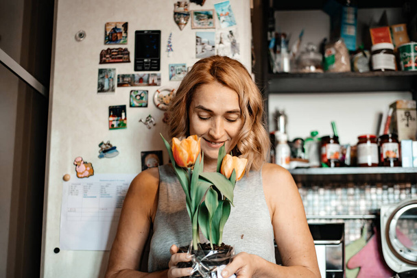 45-year-old woman holds tulips in her hands. Women's spring holiday. - Foto, Imagem