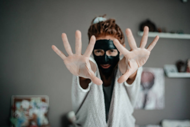 Girl in a black mask. Skin care. Cosmetology - 写真・画像