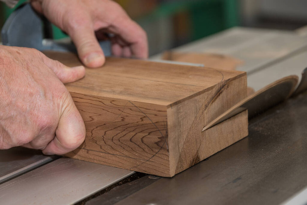 Craftsman cuts hardwood with circular saw - close-up carpenter's workshop - Photo, Image