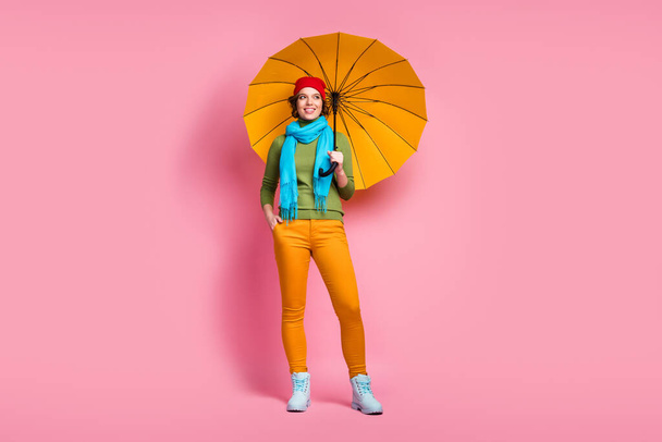 Full length photo of cheerful lovely charming girl hold her shine parasol protect her look copyspace enjoy rainy holidays wear headwear jumper isolated over pink color background - Фото, изображение