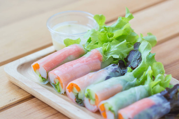 Fresh salad vegetables,noodle spring roll with salad dressing in wooden plate. - Fotografie, Obrázek