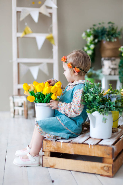  Pieni tyttö puinen penkki kevään kukkia
.  - Valokuva, kuva