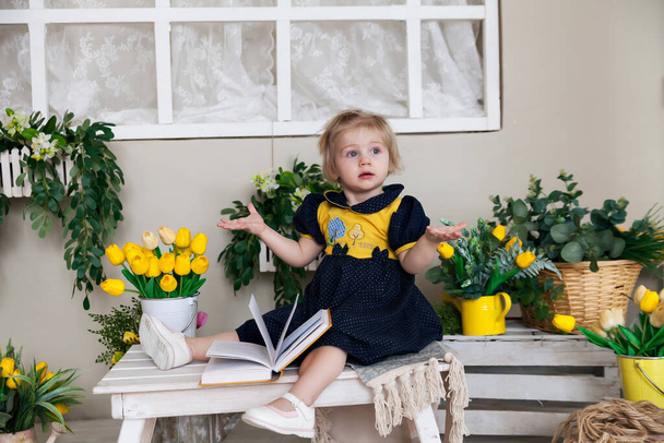  Meisje op houten bank met lentebloemen.  - Foto, afbeelding