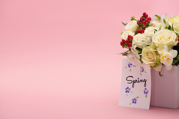 bouquet of flowers in festive gift box with spring greeting card on pink background - Photo, Image