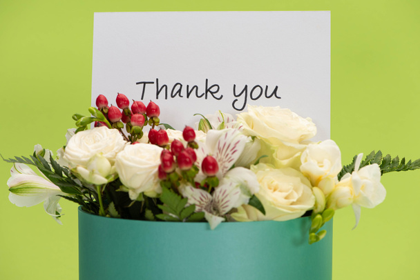fresh bouquet of flowers in gift box with thank you greeting card isolated on green - Фото, зображення
