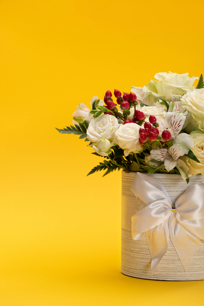 spring fresh bouquet of flowers in festive gift box with bow on yellow - Фото, изображение
