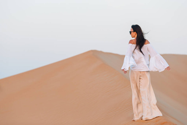 Meisje tussen duinen in de Rub al-Khali woestijn in de Verenigde Arabische Emiraten - Foto, afbeelding
