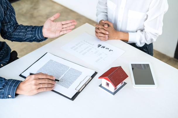 Real estate broker agent being analysis and making the decision a home estate loan to customer to signing contract documents for realty purchase, Bank employees recommend mortgage loan approval. - Photo, image