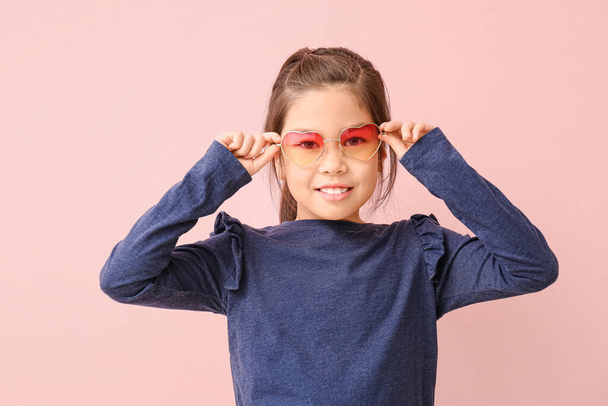 Funny little girl with sunglasses on color background - Фото, изображение