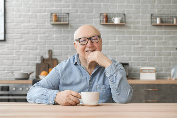 Porträt eines älteren Mannes, der Tee in der Küche trinkt - Foto, Bild