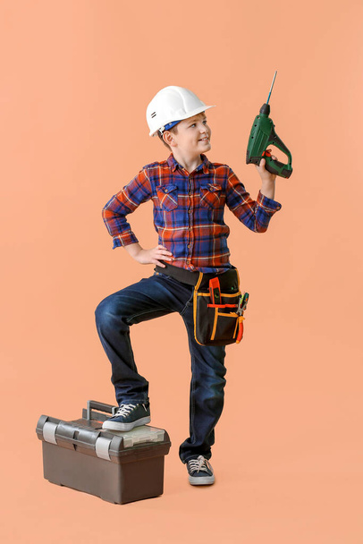 Cute little builder on color background - Foto, afbeelding