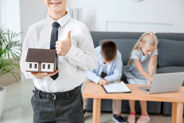 Little real estate agent with model of house and clients in office - Photo, Image
