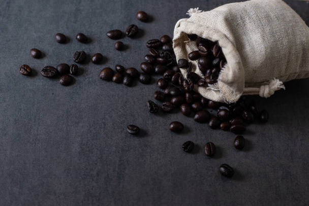 Ciemne prażone ziarna kawy domowej roboty na czarnej płycie przemysłu napojów - Zdjęcie, obraz