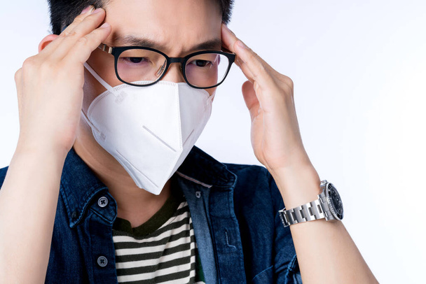 close up young asian male businessman wearing pollution mask with gesture action express ill sickness bad health from weather with pm2.5 environment city air problem - 写真・画像
