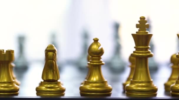 チェスゲームのピースは、黒の隔離された背景を持つチェスボード上に立つ。市場目標戦略のためのビジネスリーダーの概念。インテリジェンスチャレンジとビジネス競争の成功プレイ. - 映像、動画