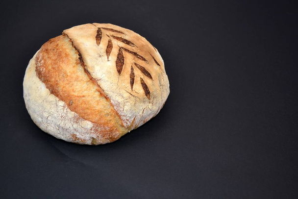 Strona główna Pieczone pszenicy / białego zakwaśnego chleba z nasionami słonecznika na czarnym tle - Zdjęcie, obraz