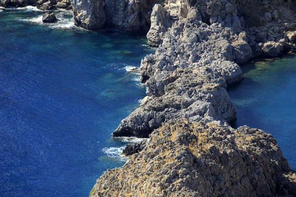 Lindos, Rhodos / Řecko - 23. června 2014: Pohled na útesy poblíž Lindosu, Rhodosu, Dodecanských ostrovů, Řecka. - Fotografie, Obrázek