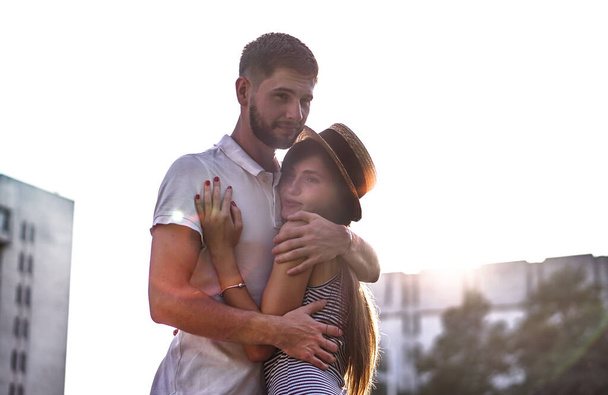 Beautiful couple of man and woman on concrete urban houses background. Romantic theme with a girl and a guy. Spring, summer photo relationship, love, Valentine's day - Photo, image