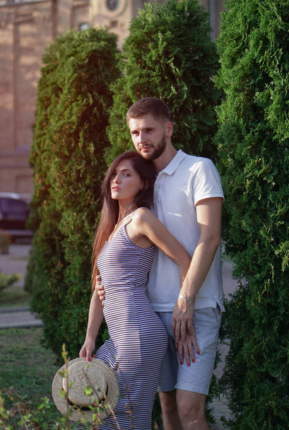 Beautiful couple of man and woman against the backdrop of a beautiful park and city architecture. Romantic theme with a girl and a guy. Spring Summer Temma relationship, love, Valentine's day - Valokuva, kuva