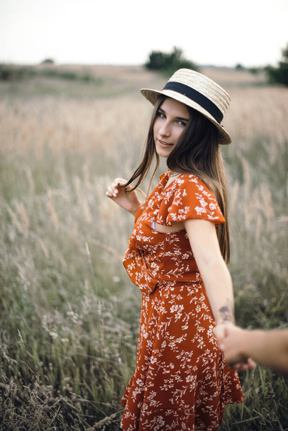 Следуйте за мной. Девушка держит руку на летнем солнечном поле
 - Фото, изображение