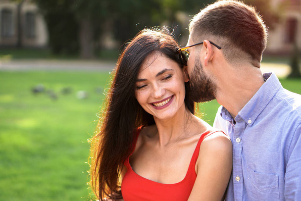 Schönes Paar von Mann und Frau auf einer Bank in einem Park. Romantisches Thema mit einem Mädchen und einem Mann. Frühlingssommerthema - Foto, Bild