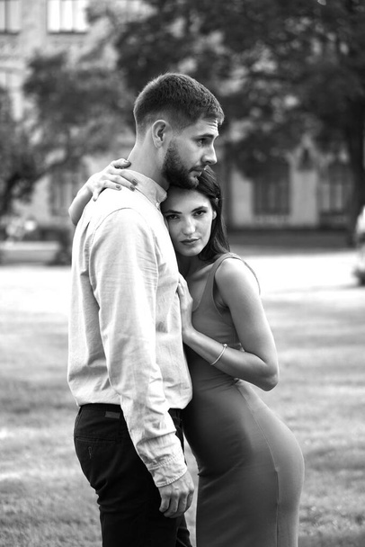 Beautiful couple of man and woman against the backdrop of a beautiful park and city architecture. Romantic theme with a girl and a guy. Spring Summer picture relationship, love, Valentine's day - Fotoğraf, Görsel