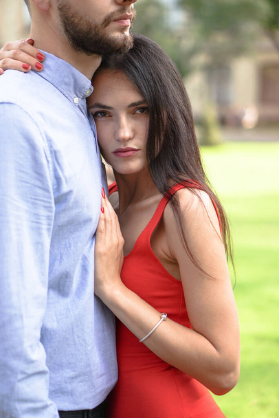 Beautiful couple of man and woman against the backdrop of a beautiful park and city architecture. Romantic theme with a girl and a guy. Spring Summer picture relationship, love, Valentine's day - Photo, Image