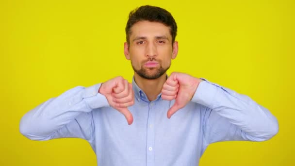 Young man in light blue shirt shows dislike, thumb down. - Filmmaterial, Video