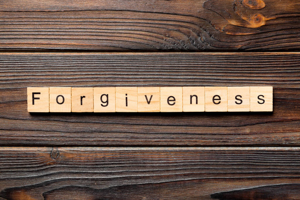 Слово прощення написане на дерев'яному блоці. текст прощення на столі, концепція
. - Фото, зображення