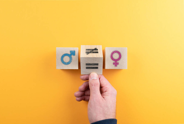 cubo in legno tornito a mano con simbolo disuguale tra icone di genere femminile e maschile
 - Foto, immagini