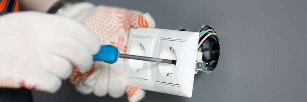 Repairman in gloves fixing socket with screwdriver - Φωτογραφία, εικόνα