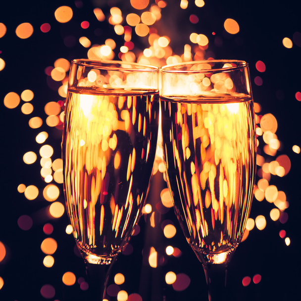 Champagne glas tegen Kerstmis sparkler achtergrond - Foto, afbeelding