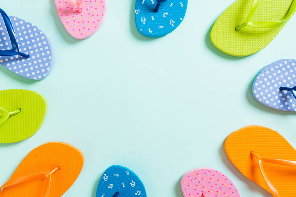a lot of flip flop colored sandals, summer vacation on colored background, copy space top view. - Photo, Image