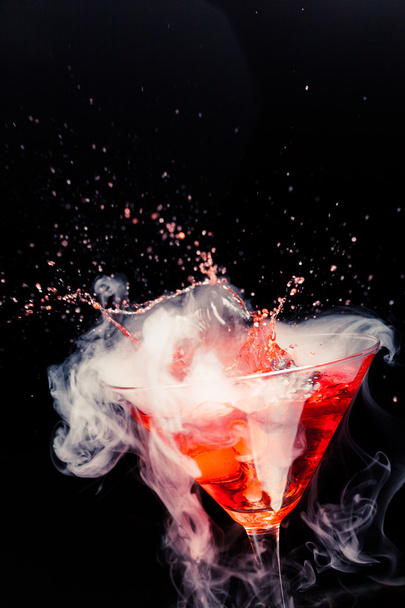 red cocktail with splash and ice vapor - Foto, afbeelding