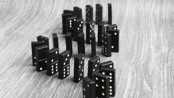 dominoes falling in a row, hand pushes a Domino and starts a chain reaction on wooden background Slow motion. Dominoes. Chain reaction. The Domino Principle - Footage, Video