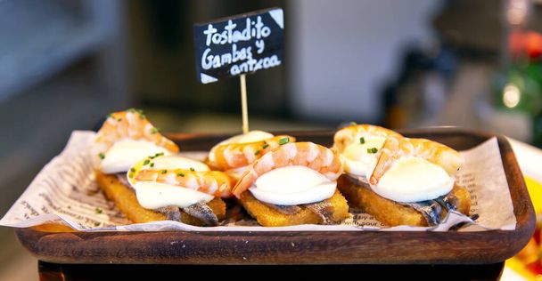 Appetitliche spanische Tapas mit Sardellen und Garnelen in Nahaufnahme im Restaurant von San Sebastian, Donostia, Spanien - Foto, Bild