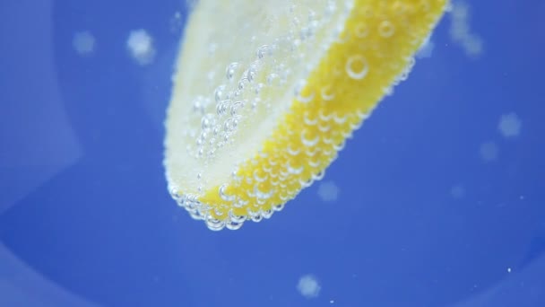 Close- up of a lemon slice with bubbles. ripe juicy fruit in water, under water. - Video, Çekim