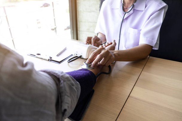 Close-up de médico está medindo sangue o homem de pressão no braço no hospital, conceitos médicos e de cuidados de saúde
. - Foto, Imagem