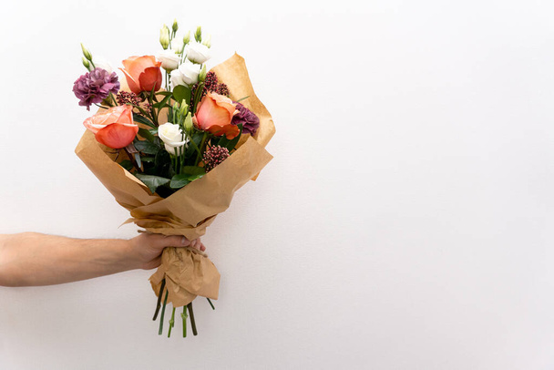 Bouquet of flowers at mans hand - Photo, image