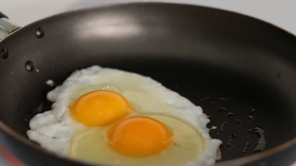 Míchaná vejce v pánvi na sporáku se solí. Video - pomalý pohyb - Záběry, video