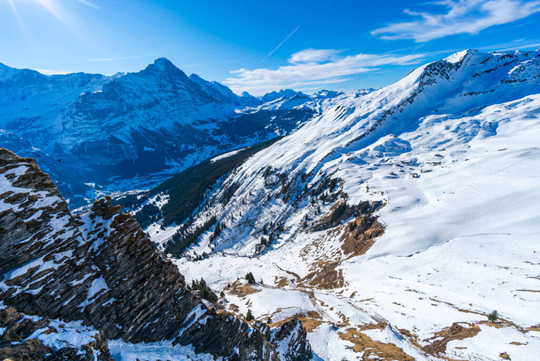 Winter landscape with snow covered peaks seen from the First mountain in Swiss Alps in Grindelwald ski resort, Switzerland - Photo, Image