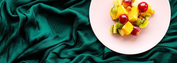 Fresh organic fruit salad on pink plate, healthy nutrition and detox diet plan, flat lay - Φωτογραφία, εικόνα