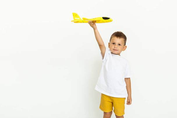Cute little boy with toy plane over white background - Photo, Image