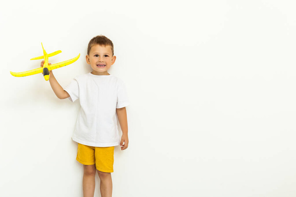 Criança criança bonito feliz brincando com avião de brinquedo amarelo e sonhando em se tornar um piloto
 - Foto, Imagem
