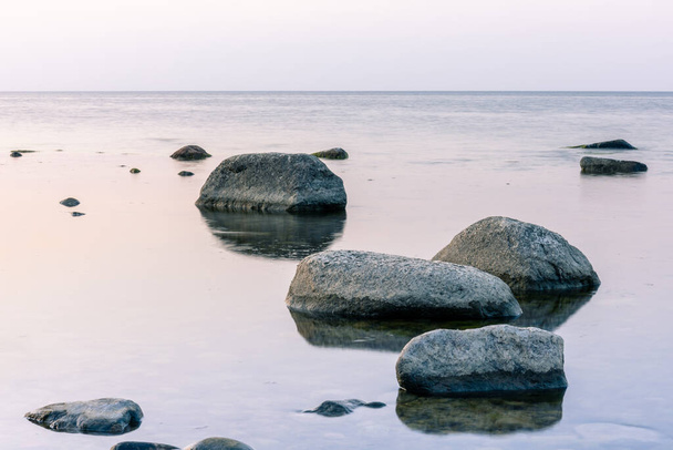спокойный пейзаж с большими камнями в море при длительной экспозиции
 - Фото, изображение
