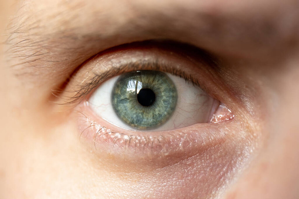 κοντινό πλάνο του αρσενικό μάτι με πράσινη ίριδα - Φωτογραφία, εικόνα